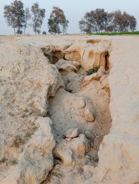 Erimiş toprak kayması çorak ve aşınmış arazi kuru toprakta derin çatlaklar ve yarıklar ile.