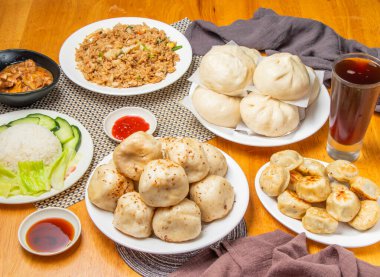 Assorted Buns, pork meat bun, pan fried buns, Egg Fried Rice, Lemongrass Chicken Rice, ice black tea and dipping sauce served in plate isolated on table side view of dim sum taiwan food clipart