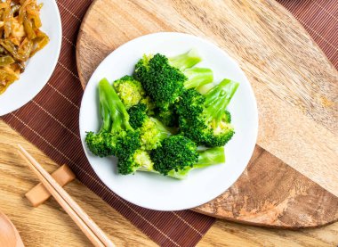 Tabakta servis edilen taze brokoli yemek çubukları ve kaşık Tayvan yemeklerinin üst görüntüsünde tahtadan izole edilmiş.