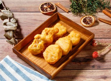 Tahta tepside servis edilen çıtır tavuklar ahşap masa kenarında izole edilmiş Tayvan atıştırmalıkları.