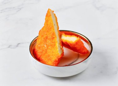 Küçük kasede servis edilen çıtır balıklı fileto mermer arka plan manzaralı Singapur yemeği.