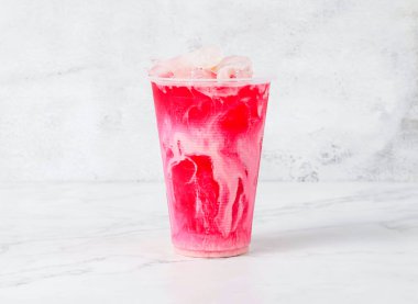 Bant gübresi ya da buz küplü buzlu çay Singapur meşrubatının mermer arka planında izole edilmiş plastik bardakta servis edilir.