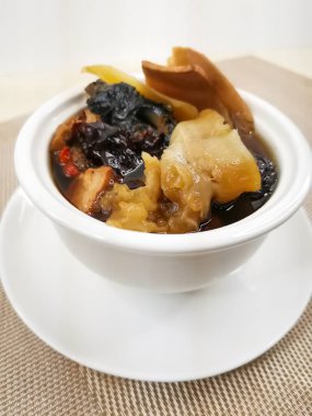 Agaricus Blazei, Fish Maw, Deniz Kabuğu Kafa ve Bambu Tavuk Çorbası arka planda Hong Kong yemeklerinin üst görüntüsünde izole edilmiş bir şekilde servis ediliyor.