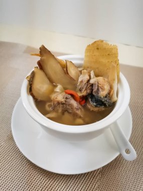 Gastrodia elata, Chuensüs ve Angelica dahurica ile birlikte balık kafası çorbası Hong Kong 'un arka planında izole edilmiş et suyunda servis edildi.