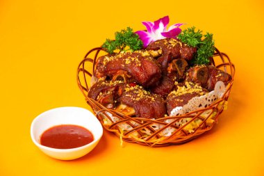 Kızarmış domuz paçası ya da kırmızı fasulyeli domuz budu Hong Kong yemeğinin turuncu arka plan manzarasında servis edilen tabakta servis edilir.