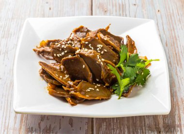 Lezzetli soslu haşlanmış tavuk böbreği, susam tohumu ve kişniş Hong Kong yemeklerini yakından izlemek için Wood Table 'da servis edilen kişniş.