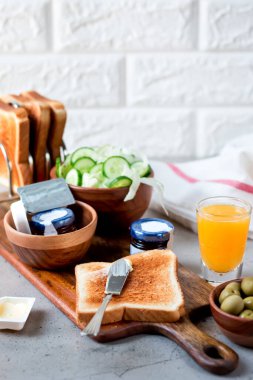 Portakal Suyuyla Kıtasal Kahvaltı tereyağı, portakal suyu, reçel kavanozu, zeytin ve dilimlenmiş salatalık ile birlikte tost içerir.
