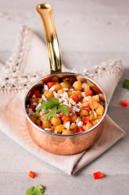 Özel Jassim Humus, Chana Chaat, Nohut Salatası. Bakır kâse kenarında servis edilen popüler Pakistan yemekleri ve sokak yemekleri.