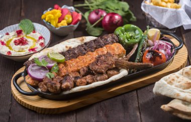 Tepside et kebabı, tavuk kebabı, tikka, boti, kuzu pirzolası, pita ekmeği, humus ve salata ile servis edilir.
