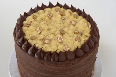 Dekoratif kremalı çikolatalı pasta. Çikolata ve krema katmanları. Kutlamalar için mükemmel olan zarif pastanın yan görüntüsü.