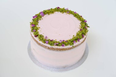 Çiçekli, şam fıstıklı ve gül yapraklı bir pasta. Kutlamalar için mükemmel bir manzara.