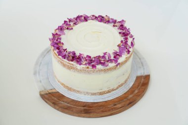 Dekoratif ahşap süslerle süslenmiş gül yapraklı pasta. Kutlamalar için mükemmel bir pasta manzarası.