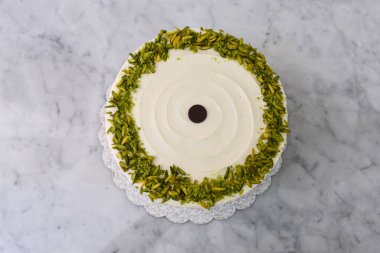 Zarif Pistachio Kek Görünür pasta katmanları ve kenarlarında doğranmış şam fıstığı ile süslenmiş pürüzsüz beyaz krema lezzetli arkaplan manzaralı lezzetli tatlı