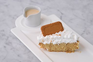 Biscoff Tres Sülükleri Süt Sosu ile dilimlenmiş kek tepside servis edilen kremayla klasik ve hoşgörülü tatlıların arka planında
