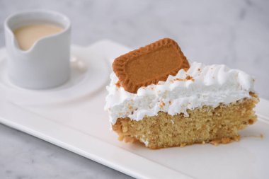 Biscoff Tres Sülükleri Süt Sosu ile dilimlenmiş krema tepside servis edilir gri arka planda izole edilmiş klasik hoşgörülü tatlı yan görüntüsü