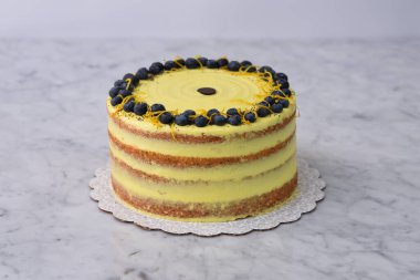 Zarif Limonlu Yaban mersinli Kek canlı sarı limonlu krema ve yeşil arkaplan manzarasında izole edilmiş yaban mersini, limon aromalı ve haşlanmış kahveli tatlı.