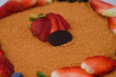 Klasik Medovik Ballı Kek. Taze çilek ve yaban mersiniyle süslenmiş. Gri arka planda izole edilmiş.