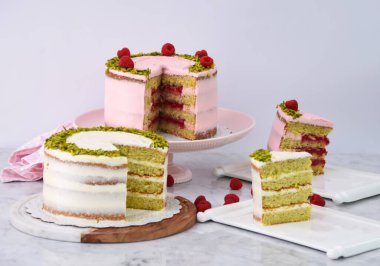 Şam fıstıklı ve ahudududulu kekler ve pembe kremalı dilimler, peçeteli ve beyaz kremalı zarif cafe tatlıları.