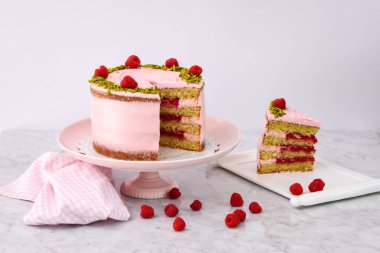 Ahudududulu Pistachio Pastası. Dilimlenmiş pembe kremalı. Taze ahududu ve dilimlenmiş fıstıklı.