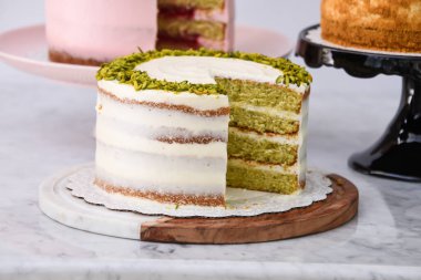 Pistachio, Medovik Bal Katmanı Keki, ve ahudududulu Kekler ve Rose Butter kremalı dilimler, pembe ve beyaz kaplama zarif tatlıların yan görüntüsü