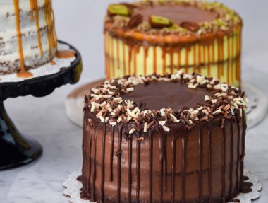 Karamel İncir, Fıstıklı Karamel ve Çikolatalı Kek 'in de aralarında bulunduğu çeşitli gurme kekler klasik tatlıların çeşitliliğinin yakın plan yan görüntüsü.