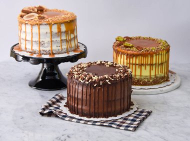 Karamel İncir, Fıstık Karamel ve peçeteye izole edilmiş çikolatalı pasta da dahil olmak üzere çeşitli gurme kekleri.