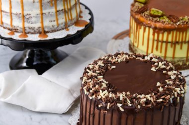 Karamel İncir, Fıstıklı Karamel ve peçeteli çikolatalı kek de dahil olmak üzere çeşitli gurme kekler zarif tatlıların yan görünüşü.