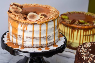 Karamel İncir, Fıstık Karamel ve Çikolatalı Kek 'in de aralarında bulunduğu çeşitli gurme kekler klasik tatlıların çeşitliliğinin yakın plan görüntüsü.