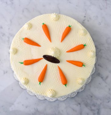 Süslü havuçlu kek, nemli ve krem peynirle kaplı baharatlı pasta katmanları leziz kekin üst manzarası.