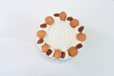 Lezzetli havuçlu kek, fındıklı süslemeler, krem peynirle kaplanmış baharatlı pasta, klasik ve lezzetli kekin üst görüntüsü.