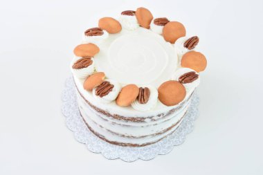 Lezzetli havuçlu kek, fındıklı süslemeler, krem peynirle kaplanmış baharatlı pasta, krem peynirle kaplanmış klasik ve lezzetli pastanın üst görüntüsü.