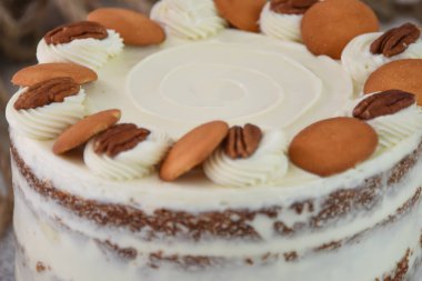 Lezzetli havuçlu kek, fındıklı süslemeler, krem peynirle kaplanmış baharatlı pasta, krem peynirle kaplanmış klasik ve lezzetli pastanın yakın görüntüsü.