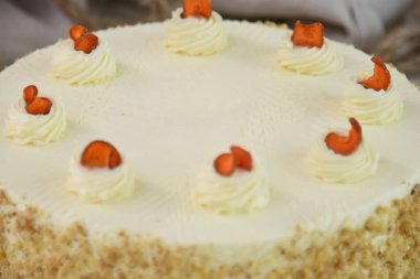 Krem peynirli havuçlu kek ve yumuşak krem peynirli pasta katmanlarıyla kaplı yumuşak krem peynirli pasta zarif bir şekilde karamelli yakın plan pasta görüntüsüyle serpilmiştir.