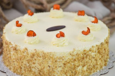 Krem peynirli havuçlu kek ve yumuşak krem peynirli pasta katmanlarıyla kaplı yumuşak krem peynirli pasta zarif bir şekilde karamelli yakın plan pasta görüntüsüyle serpiştirilmiş.