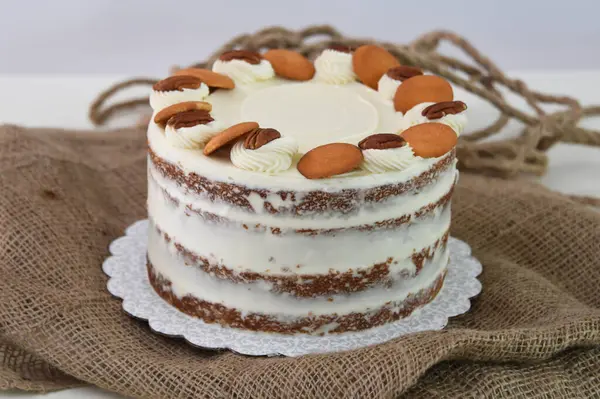 Lezzetli havuçlu kek, fındıklı süslemeler, krem peynirle kaplanmış baharatlı pasta, peçete tarafından izole edilmiş, klasik ve lezzetli pasta.