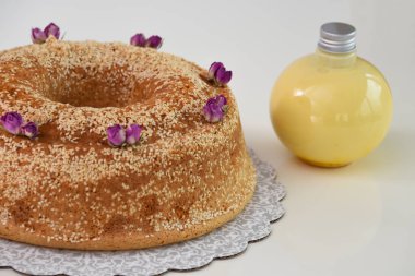 Zarif lavantalı kek, pudra şekeriyle hafifçe tozlanmış ve üzerine beyaz jöle serpiştirilmiş ve susam tohumları serpiştirilmiş.