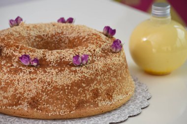 Zarif lavantalı kek, pudra şekeriyle hafifçe tozlanmış ve üzerine beyaz jöle serpiştirilmiş ve susam tohumları serpiştirilmiş benzersiz kafe tatlısının yakın görüntüsü.