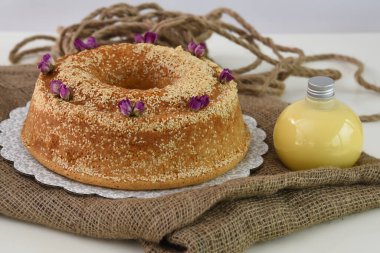 Zarif lavantalı kek, pudra şekeriyle hafifçe tozlanmış ve üzerine beyaz jöle serpiştirilmiş ve peçeteye izole edilmiş susam tohumları serpiştirilmiş.