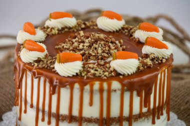 Krem peynirli havuçlu kek ve karamelli karamel soslu ezilmiş fındıklı ve peçeteye izole edilmiş klasik lezzetli pasta.