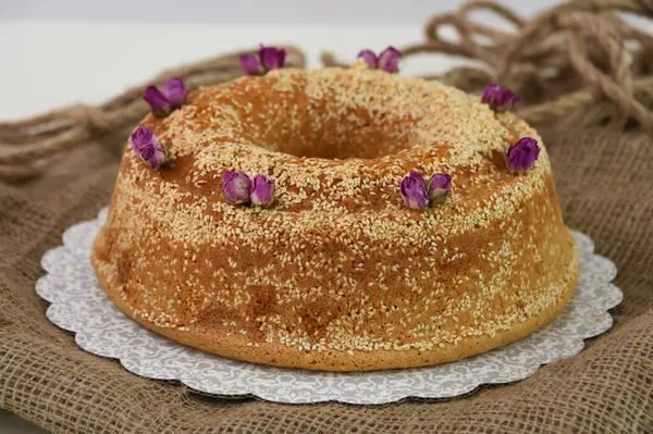 Zarif lavantalı kek, pudra şekeriyle hafifçe tozlanmış ve üzerine beyaz jöle serpiştirilmiş ve susam tohumlu klasik tatlı.