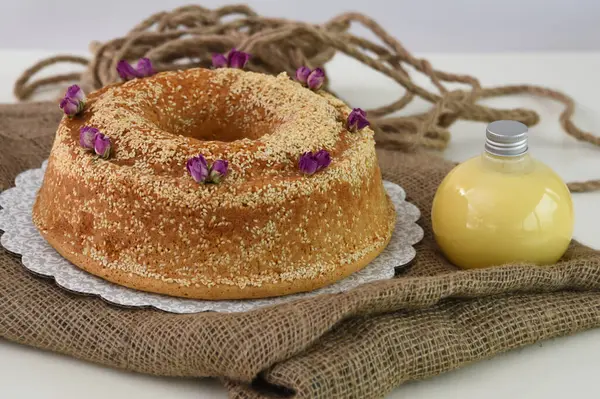 Zarif lavantalı kek, pudra şekeriyle hafifçe tozlanmış ve üzerine beyaz jöle serpiştirilmiş ve peçeteye izole edilmiş susam tohumları serpiştirilmiş.