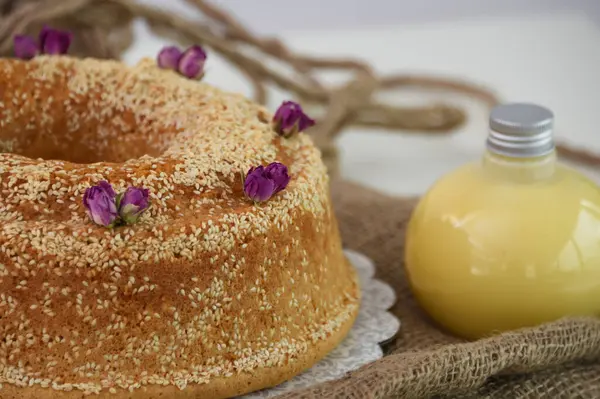 Zarif lavantalı kek, pudra şekeriyle hafifçe tozlanmış ve üzerine beyaz jöle serpiştirilmiş ve peçeteye izole edilmiş susam tohumları serpiştirilmiş eşsiz tatlı.