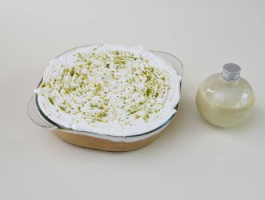 Krem şantili, şeffaf bir bardakta limonlu turta ve parlak yeşil limon lezzeti ile tozlanmış klasik fırında pişirilmiş tatlı sosu.