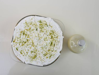 Krem şantili, şeffaf bir bardakta limonlu turta ve parlak yeşil limon lezzeti ile tozlanmış klasik tatlı manzaralı soslu.