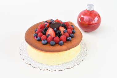 Çilek, ahududu, böğürtlen ve böğürtlen soslu yumuşak Japon cheesecake 'i. Lezzetli ve popüler tatlı manzaralı kırmızı böğürtlen sosu.