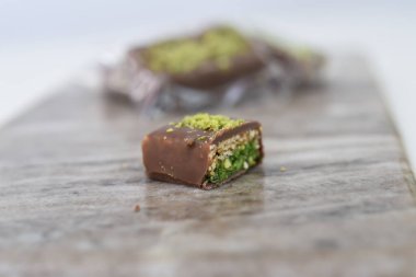 Çikolatalı Pistachio çikolatası ve Wafer katmanları çikolata tabakası, ince çıtır gofret katmanları ve tatlı ikramının yeşil şam fıstıklı yan görüntüsünü gözler önüne sermek için ikiye bölündü.