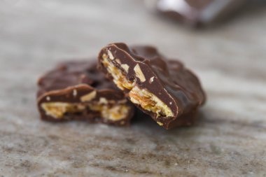 Çikolata Fındık Kümeleri, kalın çikolata kaplama katmanlı tatlı ikramının hoşgörüsünü ön plana çıkarıyor.