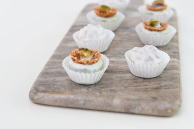 Çeşitli Beyaz Çikolata ve Fındık Mantarlı mini tatlı Mermer Yönetim Kurulu tarafından izole edilmiş Tatlı Tatlı Tatlı Tatlılar Görünümü