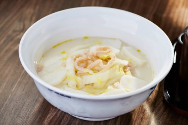 Napa Lahanalı doğranmış domuz eti ve pirinç keki çorbası. Otantik Çin Erişte Çorbası 'nın kâse kenarında servis ediliyor.