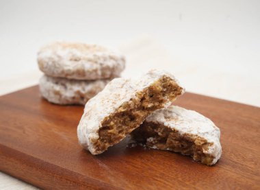 Lezzetli karışık fındıklı kurabiye tozlu toz şekerle ikiye bölünmüş Tahta tahtadaki zenginliğini göstermek için tatlı atıştırmalık